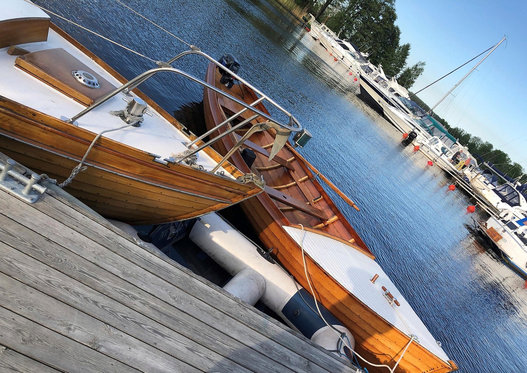 Två träbåtar vid brygga i Askersunds hamn.