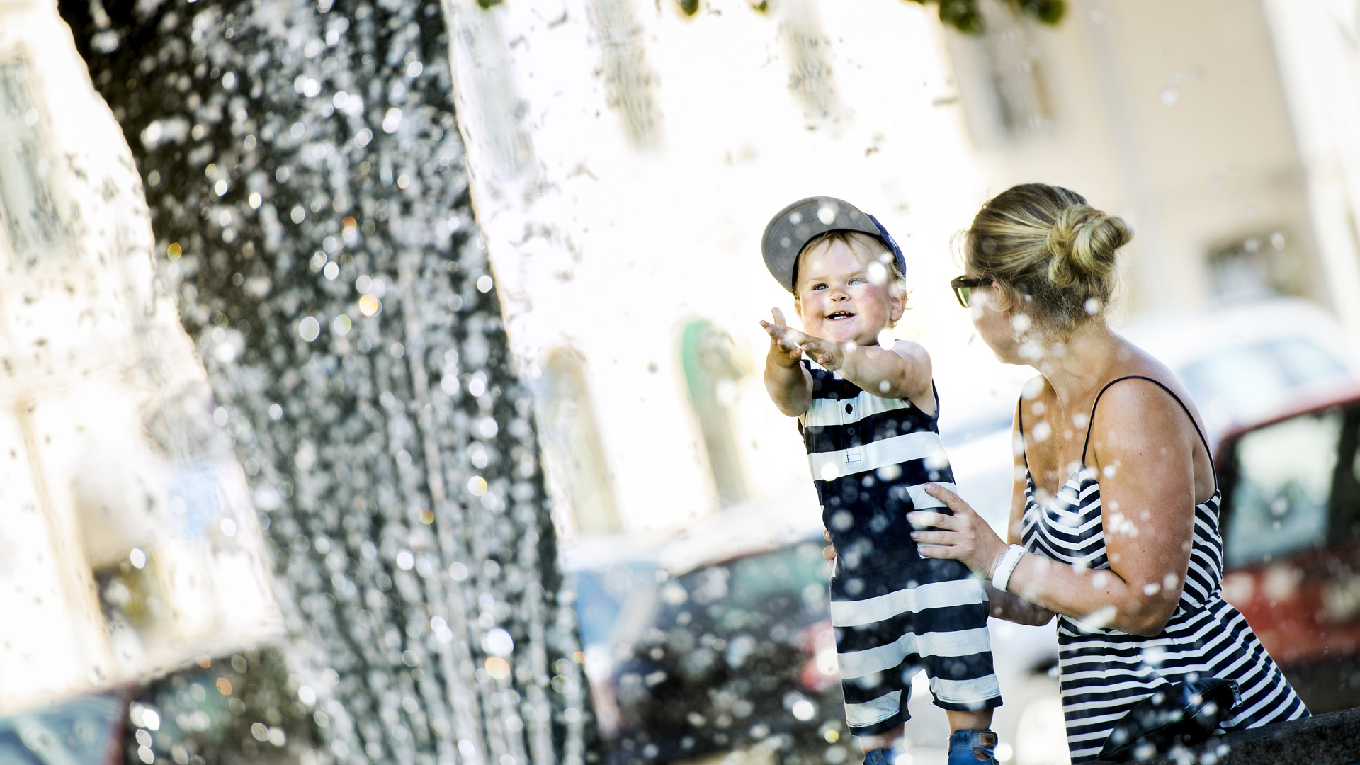 Mamma med barn står vi fontänen i Torgparken i Askersund