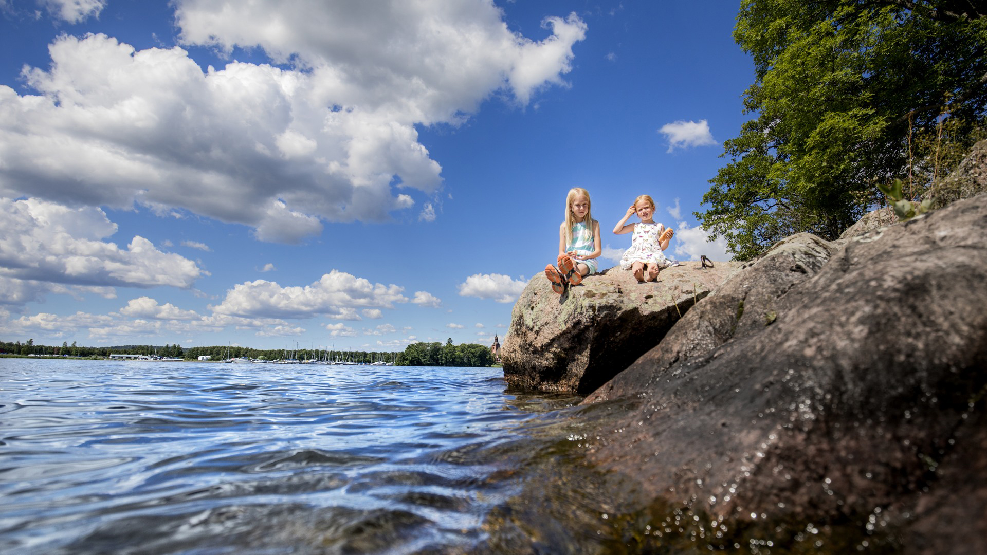 Två tjejer sitter på klipporna vid sjön Alsen