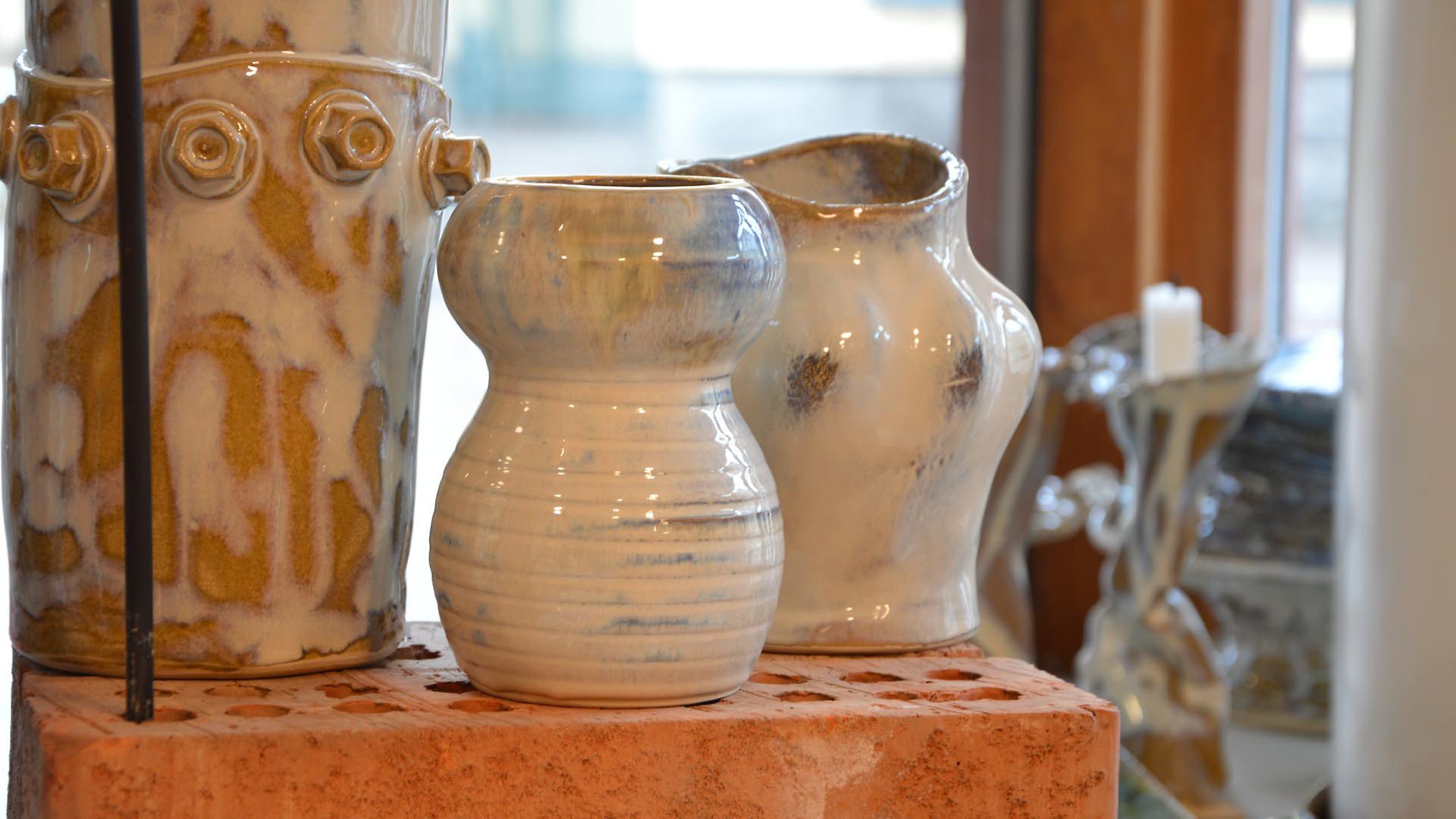 Keramikvaser stående på tegelblock i ett fönster.