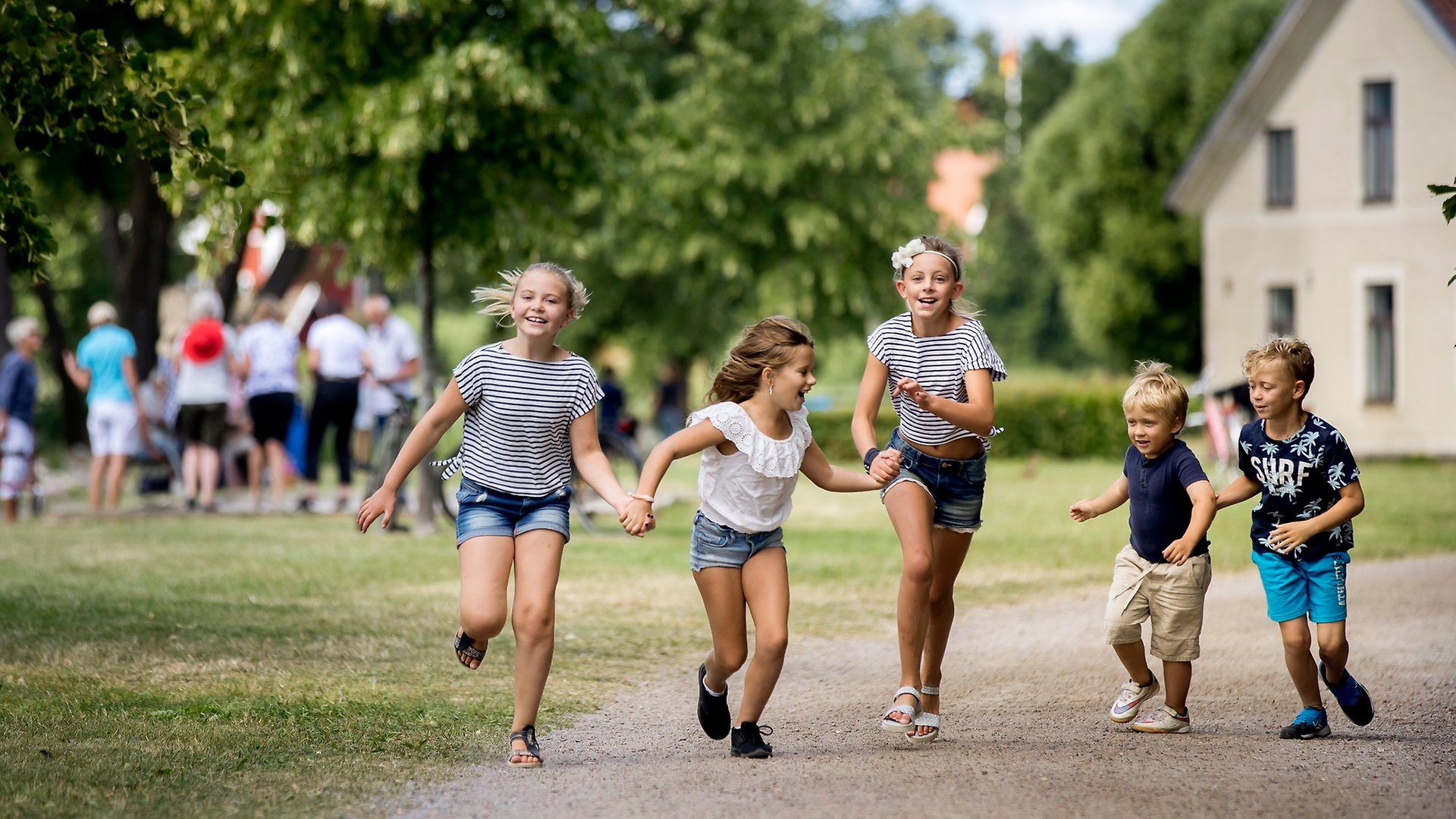 Flera barn som springer längs med strandpromenaden i Askersund.