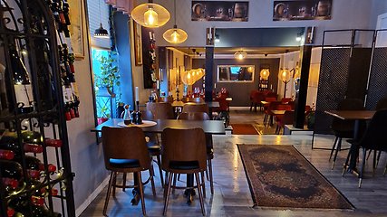 Interiör på restaurangen Casa Mia. Vinställ till vänster i bilden. bord och stolar, matta på golvet, varm belysning i taket.