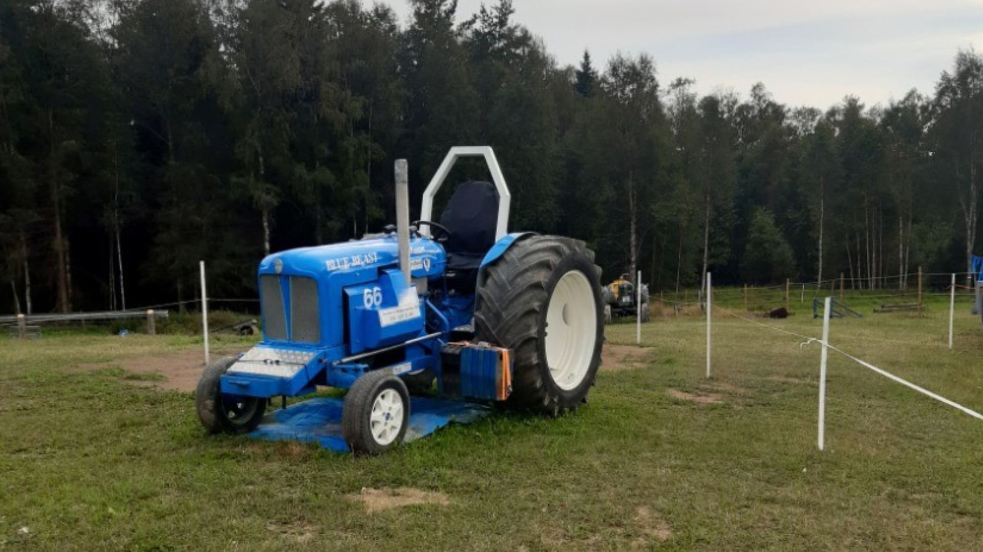 Blå traktor vid traktorpulling.