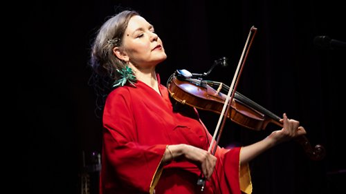 Kvinna i röd klänning spelar fiol